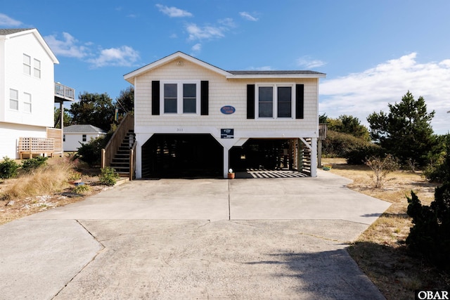 view of front of house with a carport, concrete driveway, and stairs