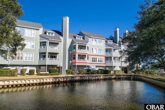 back of house featuring a chimney and a water view