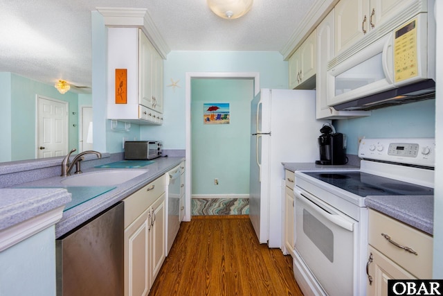 314 Pirates Way Unit 314B, Manteo, NC 27954 - kitchen with white appliances, a sink, dark wood finished floors, light countertops, and white cabinets