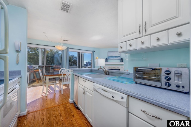 314 Pirates Way Unit 314B, Manteo, NC 27954 - kitchen with white appliances, a sink, wood finished floors, and white cabinets