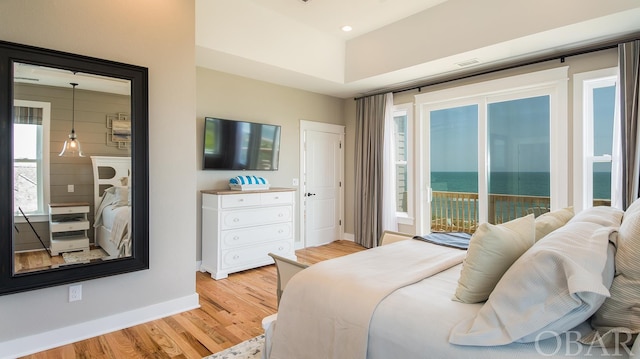 bedroom with light wood-type flooring, access to outside, multiple windows, and baseboards