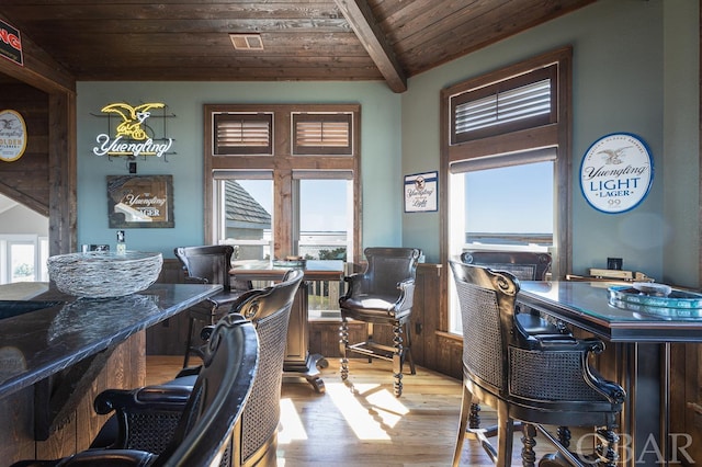 dining space featuring plenty of natural light, light wood-type flooring, wooden ceiling, and visible vents