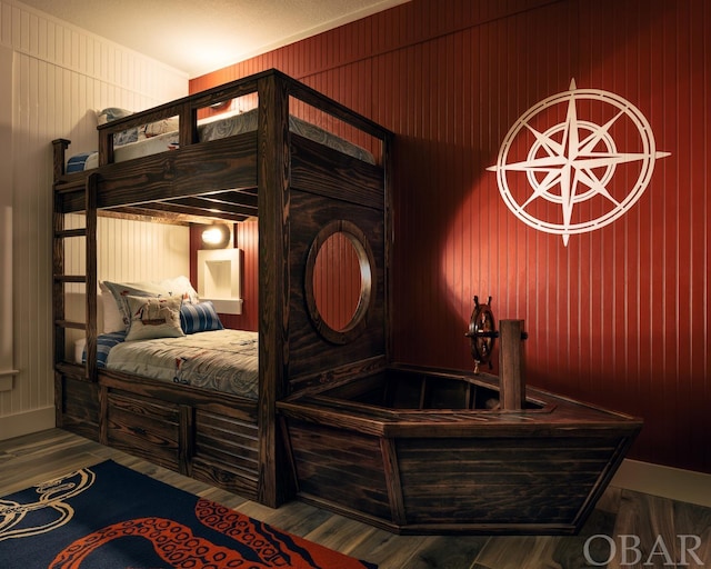 bedroom featuring wood walls and wood finished floors