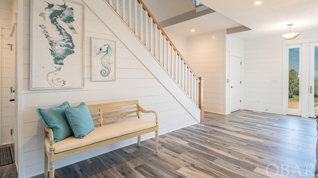 interior space with wood walls, stairway, wood finished floors, and recessed lighting