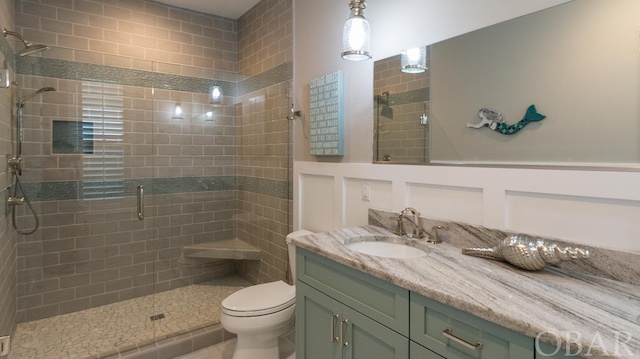 full bath featuring toilet, a shower stall, and vanity