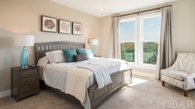 bedroom with baseboards and light colored carpet