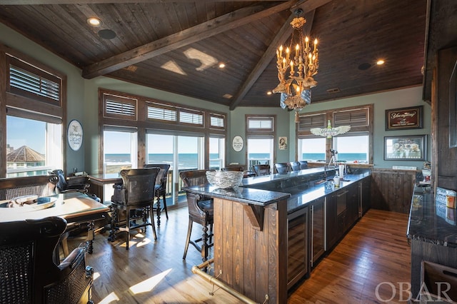 kitchen featuring wooden ceiling, a water view, an inviting chandelier, and a kitchen breakfast bar