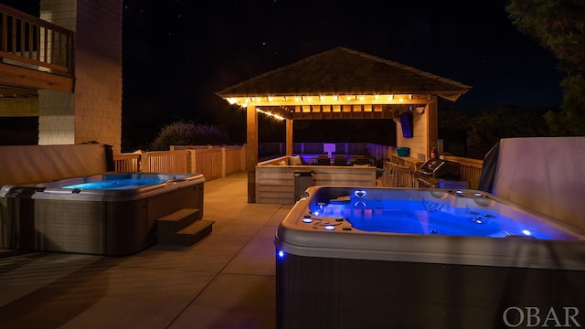 patio at twilight with a covered hot tub and a gazebo