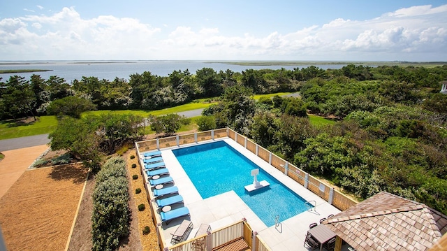 view of swimming pool with a fenced in pool, a patio, a water view, fence, and a diving board