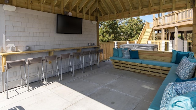 view of patio / terrace featuring stairway, a covered hot tub, outdoor lounge area, and outdoor dry bar