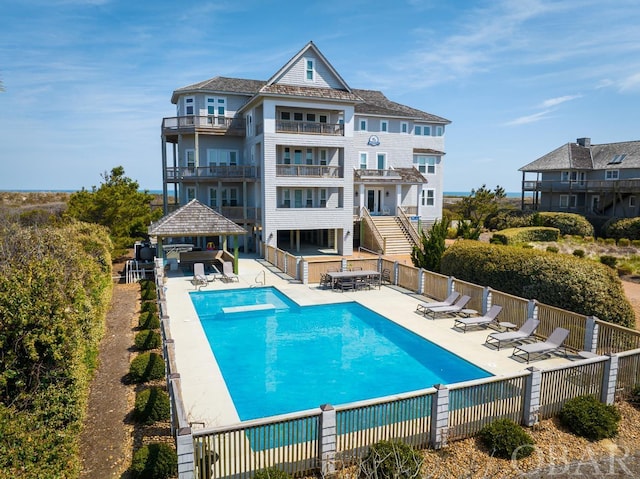 community pool featuring a patio area, fence, a bar, and a gazebo