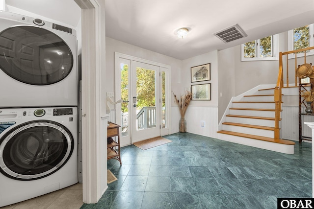 1148 Dunton Dr Lot 337, Corolla, NC 27927 - laundry room featuring visible vents, stacked washer and clothes dryer, and wainscoting
