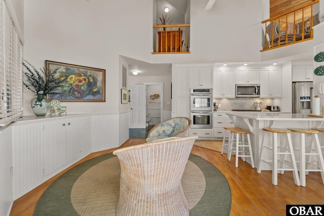 1148 Dunton Dr Lot 337, Corolla, NC 27927 - dining area with light wood-style floors, wainscoting, and a high ceiling