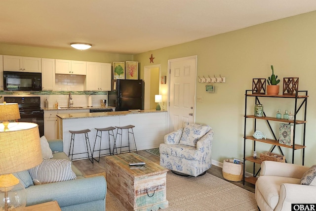 living area with baseboards and wood finished floors