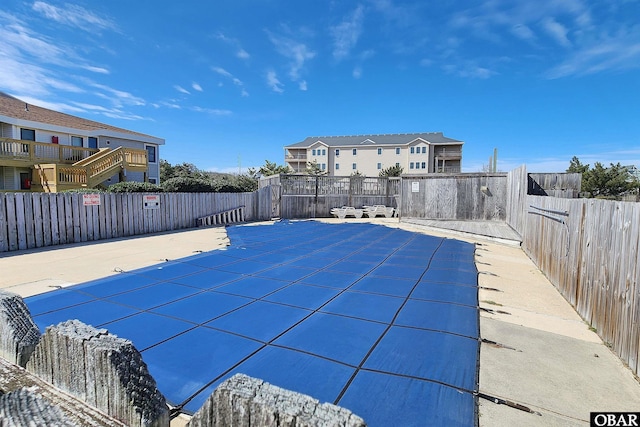 community pool featuring a patio area and a fenced backyard