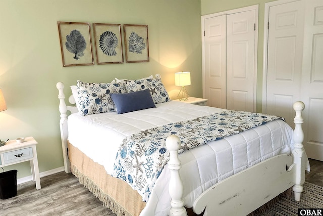 bedroom featuring a closet, wood finished floors, and baseboards