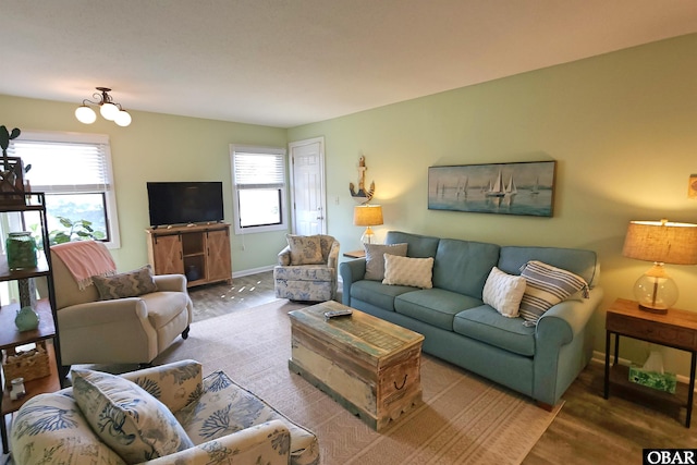 living room featuring a chandelier and baseboards