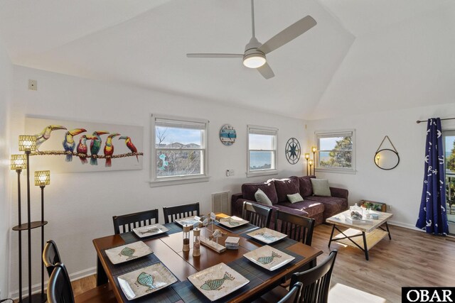 dining room with a ceiling fan, visible vents, vaulted ceiling, and wood finished floors