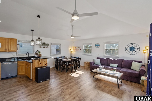 living area featuring lofted ceiling, ceiling fan, baseboards, and wood finished floors