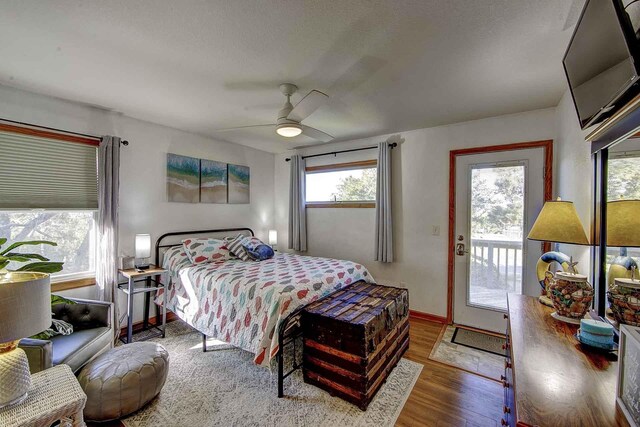 bedroom featuring access to outside, ceiling fan, baseboards, and wood finished floors