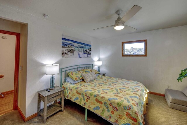 carpeted bedroom with ceiling fan and baseboards