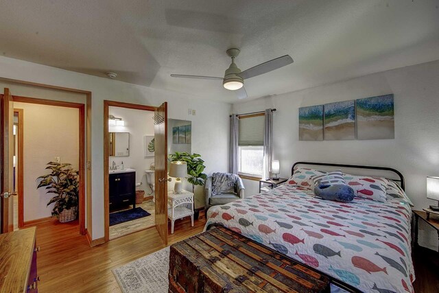 bedroom with a textured ceiling, a ceiling fan, and wood finished floors