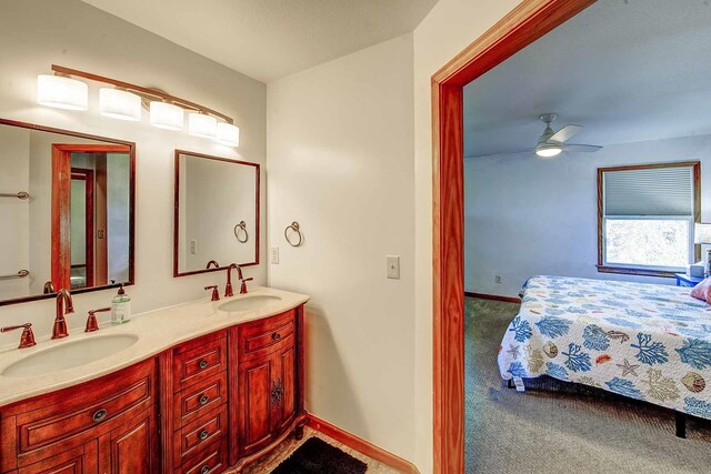 ensuite bathroom featuring double vanity, ceiling fan, a sink, and ensuite bathroom