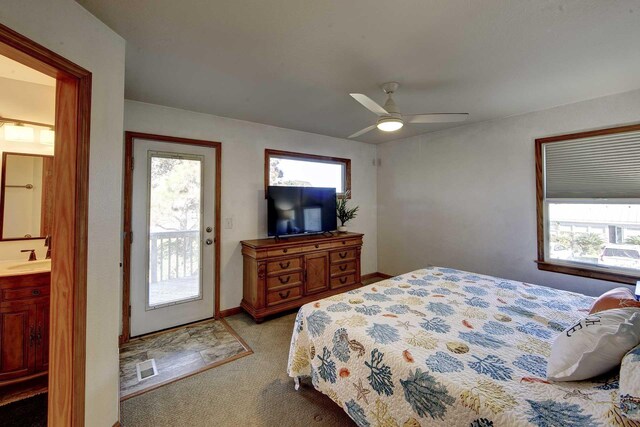 bedroom with ceiling fan, light carpet, a sink, access to outside, and ensuite bath