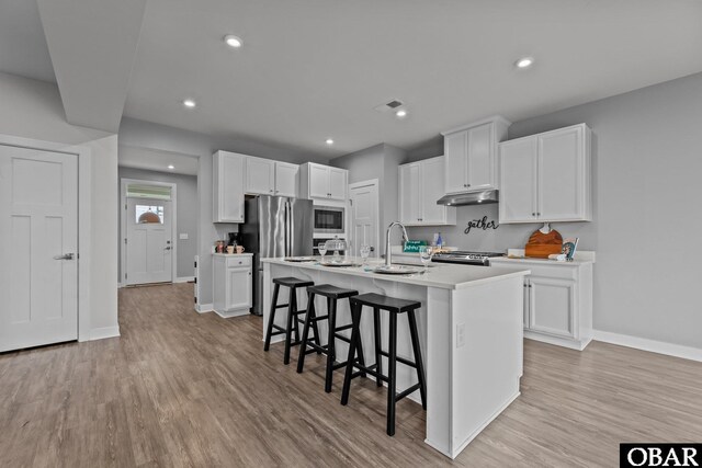307 Sunny Lk Lot 106, Moyock, NC 27958 - kitchen featuring appliances with stainless steel finishes, a kitchen breakfast bar, light wood-style flooring, white cabinetry, and recessed lighting