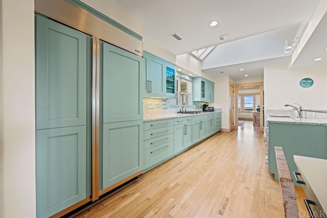 interior space with visible vents, wood finished floors, vanity, backsplash, and recessed lighting