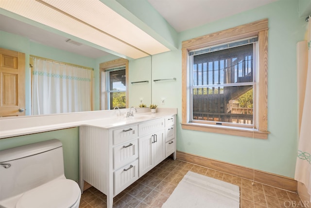 bathroom featuring baseboards, vanity, and toilet