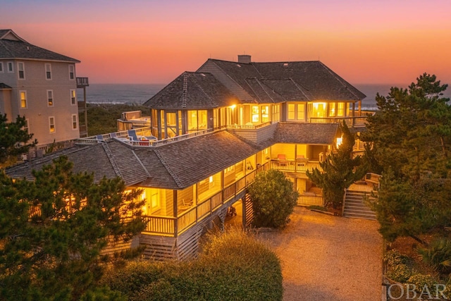 view of front of house featuring a balcony and a chimney