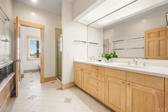 full bath with a sink, a shower stall, and double vanity