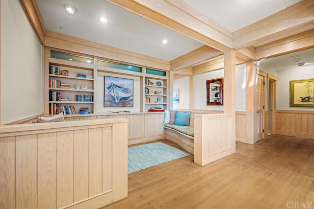 unfurnished office featuring recessed lighting, built in features, light wood-type flooring, wainscoting, and beam ceiling