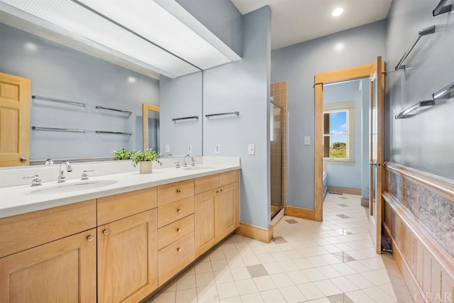 full bathroom featuring double vanity, a stall shower, tile patterned flooring, and a sink