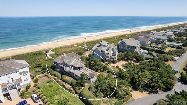 drone / aerial view featuring a view of the beach, a water view, and a residential view