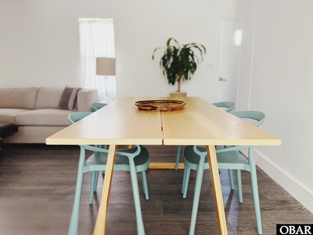 dining space with dark wood-type flooring and baseboards