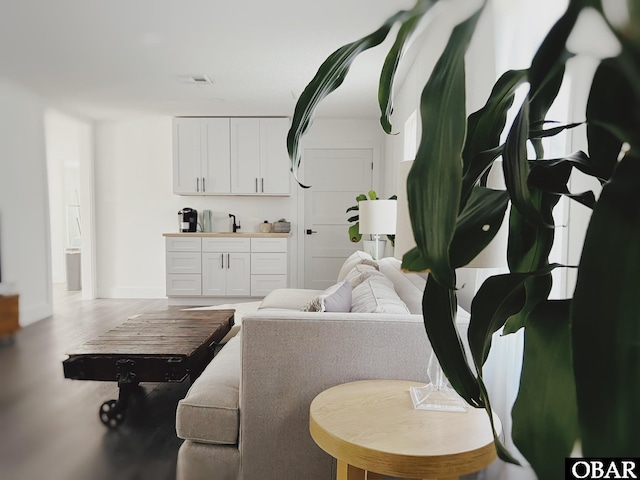 living area with visible vents and wood finished floors