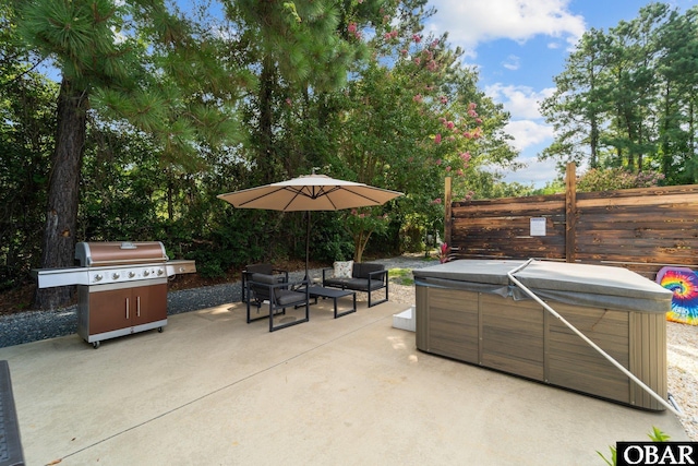 view of patio / terrace featuring grilling area, fence, and a hot tub