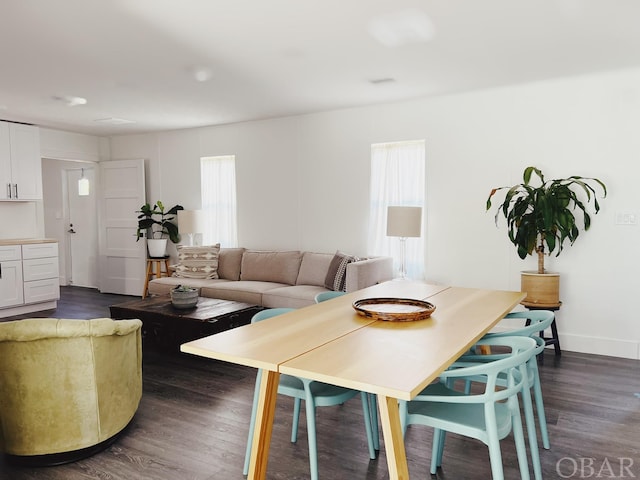 dining area with baseboards and dark wood-style flooring