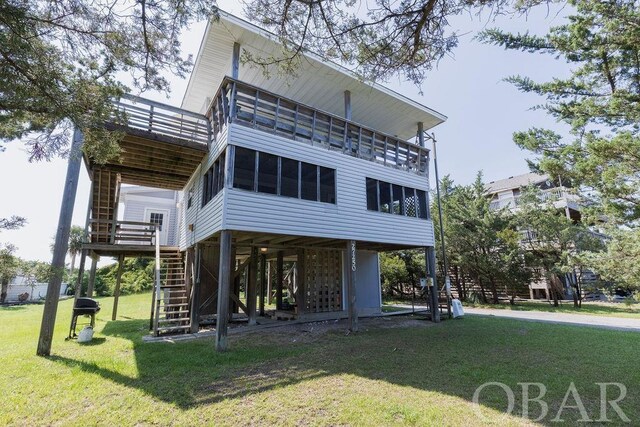 back of house with a sunroom, stairway, and a yard