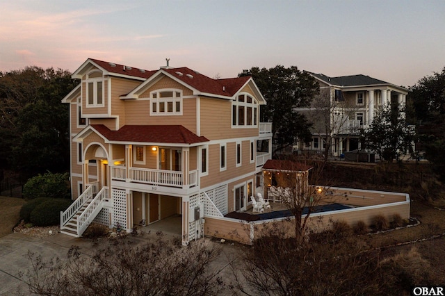 view of front of house with a garage, driveway, stairs, and a porch