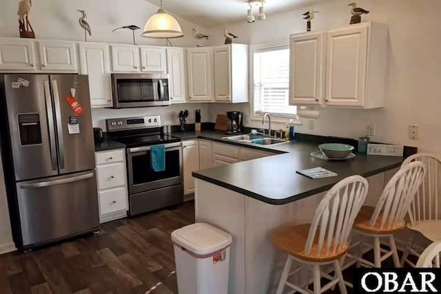 703 Suffolk St Lot 934, Kill Devil Hills, NC 27948 - kitchen with appliances with stainless steel finishes, a sink, dark wood-style flooring, a peninsula, and dark countertops