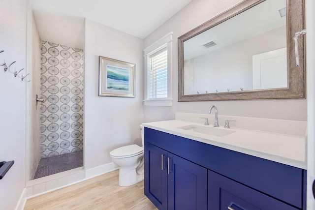 full bath featuring visible vents, toilet, wood finished floors, walk in shower, and vanity