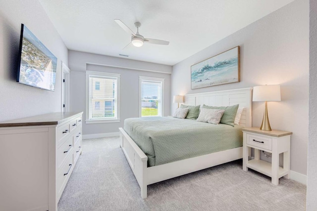 bedroom featuring ceiling fan, baseboards, and light colored carpet