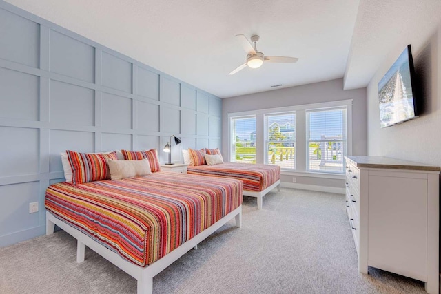 bedroom featuring light colored carpet and a decorative wall