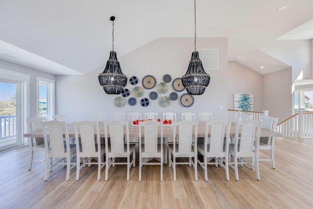 dining room with vaulted ceiling, light wood-type flooring, and a wealth of natural light