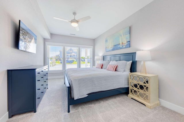 bedroom with light carpet, baseboards, and a ceiling fan