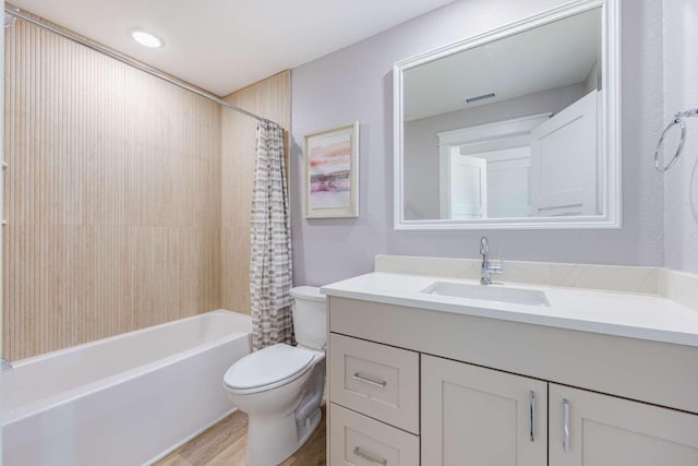 full bath with toilet, shower / tub combo, wood finished floors, visible vents, and vanity