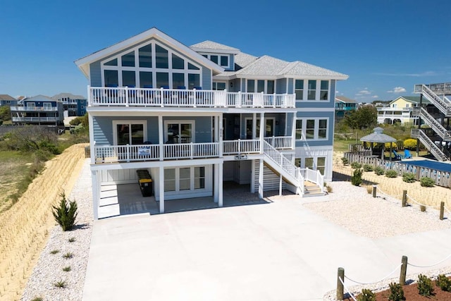 rear view of property featuring driveway, a residential view, and a balcony